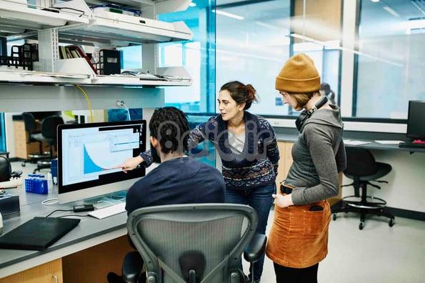 افرادی که در یک آزمایشگاه به داده‌های بخش‌بندی Google Analytics نگاه می‌کنند